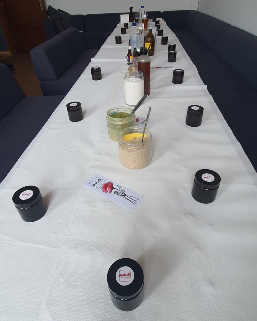 A workshop table prepared for a Women's Day DIY natural cosmetics class, featuring jars of handmade cosmetics, natural ingredients, and mixing tools for creating skincare products.