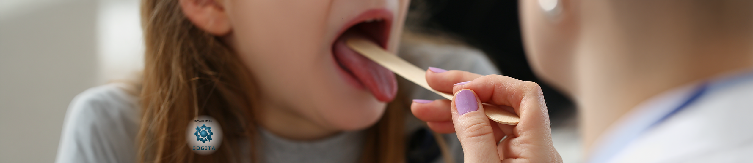 A healthcare professional uses a tongue depressor to examine a patient’s mouth and throat.